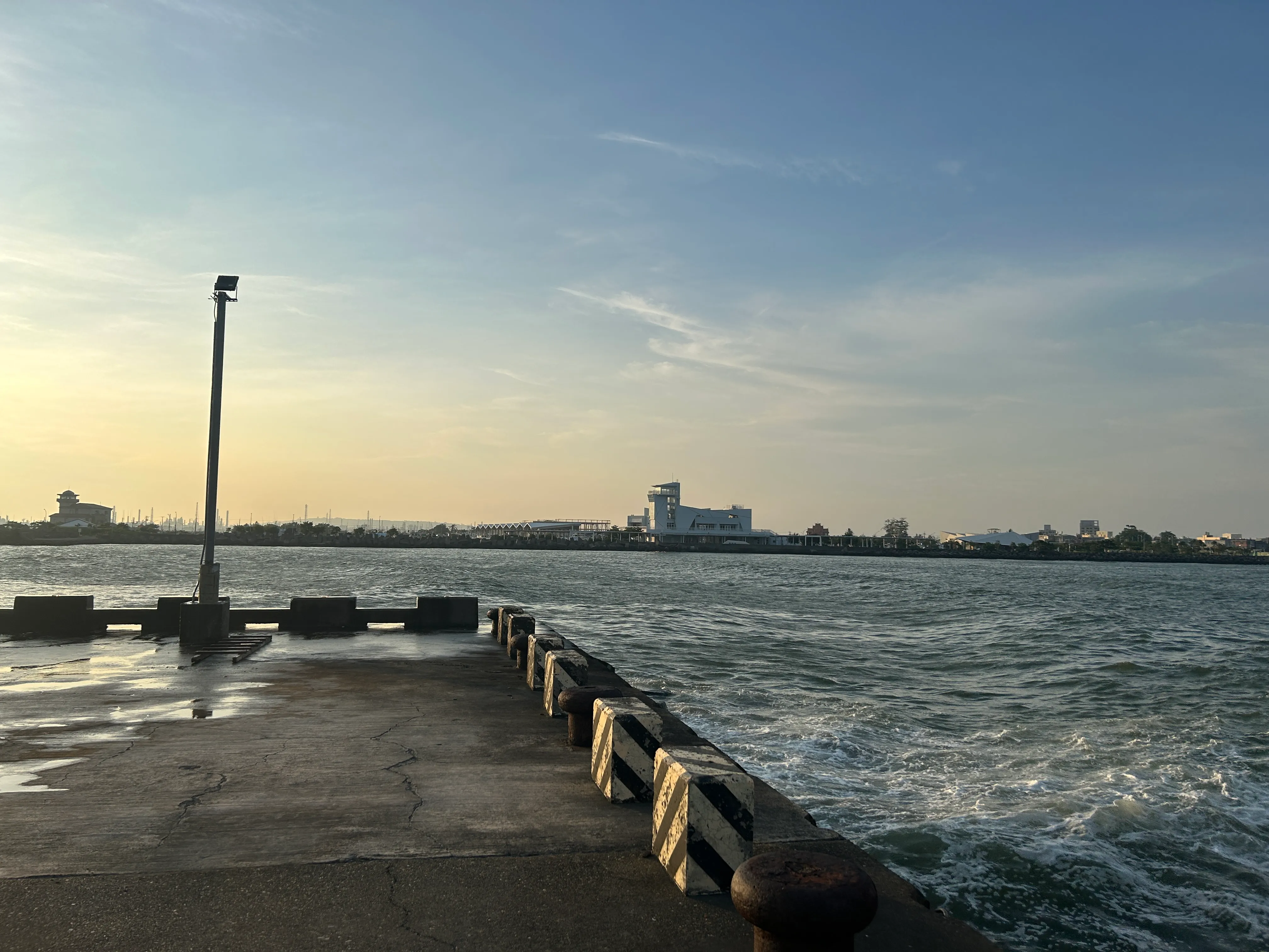 The sea wall at Donggang at dusk, harbour buildings across the water